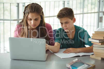 School kids using laptop in library