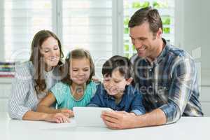 Family using digital tablet in living room at home