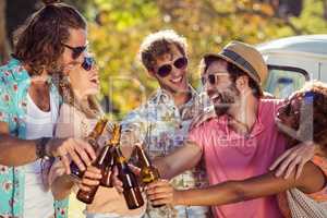 Group of friends toasting beer bottles