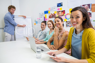 Portrait of smiling executives sitting in conference room during meeting