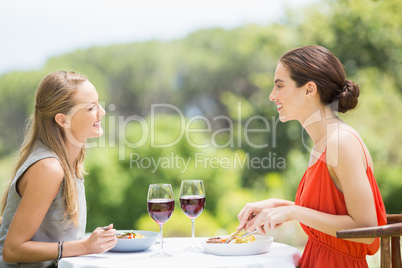 Happy friends smiling while having food