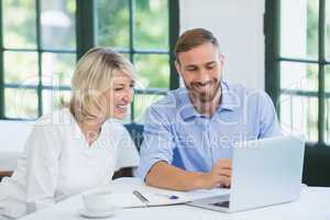 Executives discussing over laptop