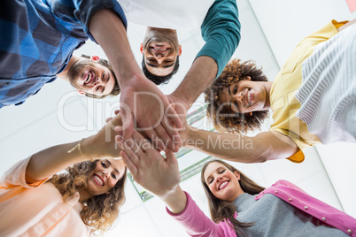 Team of smiling executives forming hand stack