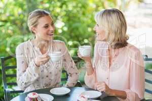 Smiling friends enjoying coffee together