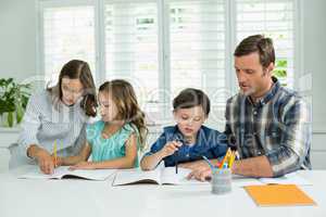 Siblings getting help with homework from parents