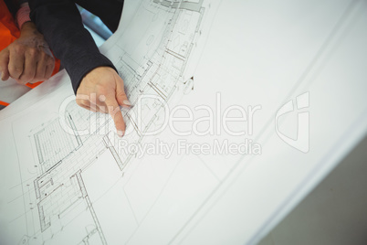 Hand of businesswoman pointing at area on blueprint