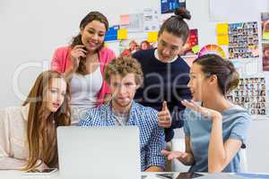 Executives discussing over laptop in office