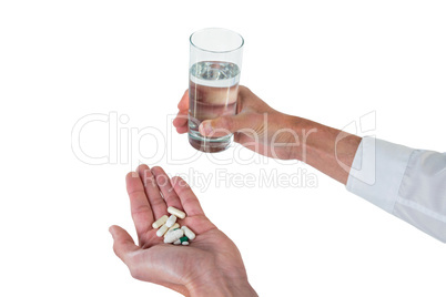 Executive holding glass of water and medicines