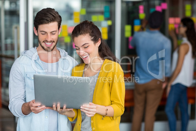 Smiling executives using laptop