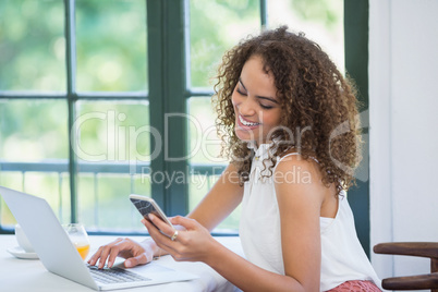 Beautiful woman using mobile phone and laptop