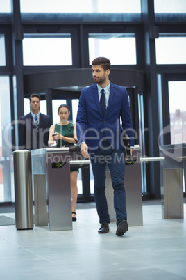 Businessman passing through turnstile gate