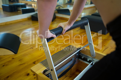 Mid section of woman exercising on reformer