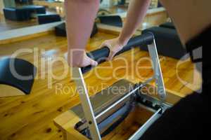 Mid section of woman exercising on reformer