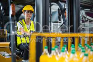 Female factory worker driving forklift in factory