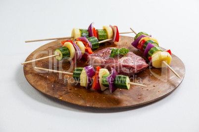 Sirloin chop and skewered vegetables on wooden board