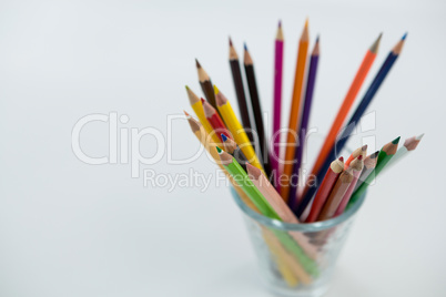 Colored pencils kept in glass on white background