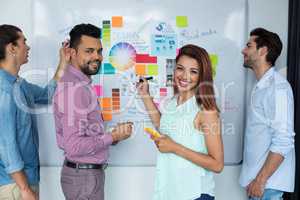 Business executives discussing over white board in office