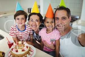 Happy family taking a selfie while celebrating a birthday