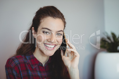 Female executive talking on mobile phone in office