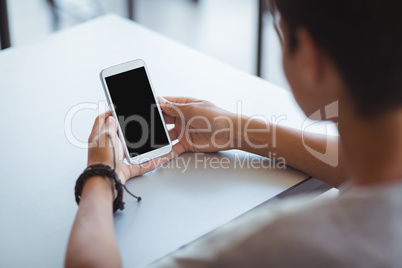 Schoolboy using mobile phone in classroom