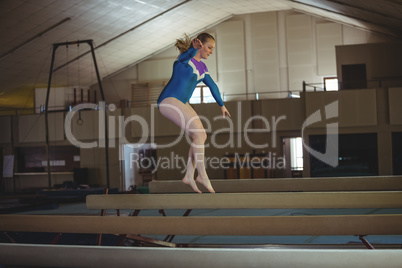 Female gymnast practicing gymnastics on the balance beam