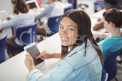Student holding digital tablet in classroom