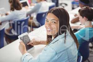 Student holding digital tablet in classroom