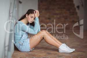 Sad schoolboy sitting in corridor