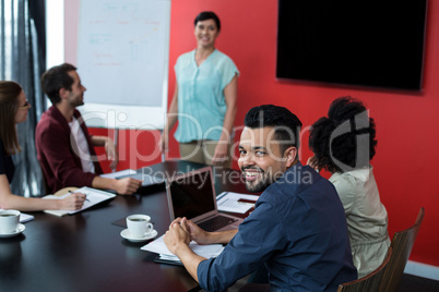 Business executives discussing over flip chart during meeting
