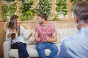 Couple arguing in counseling session with a doctor