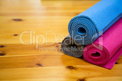 Rolled-up exercise mat on wooden floor