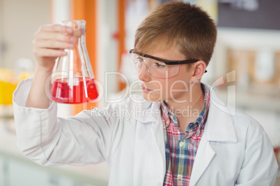 Attentive schoolboy doing a chemical experiment in laboratory Attentive schoolboy doing a chemical experiment in laboratory