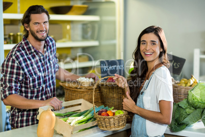 Smiling woman interacting with vendor while buying fruits in the grocery store