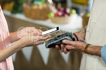 Woman making a payment by using NFC technology