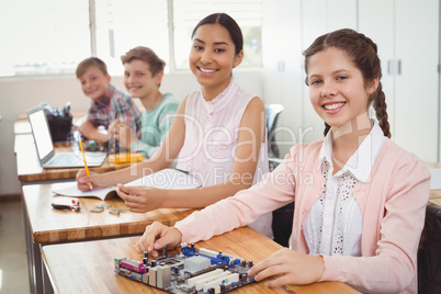 Portrait of smiling students studying in classroom