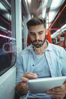 Executive using digital tablet travelling in train
