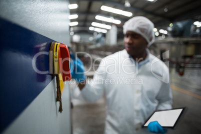 Factory engineer operating machine in factory