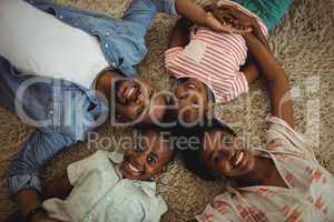 Portrait of happy parents and kids lying on rug