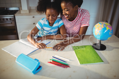 Mother assisting daughter with homework