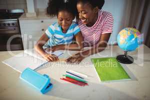 Mother assisting daughter with homework