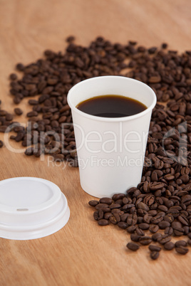 Coffee beans and black coffee in disposable cup