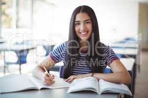 Schoolgirl doing homework in classroom