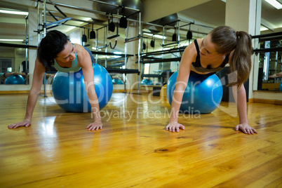 Women interacting while exercising on fitness ball