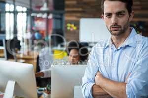 Man with arms crossed standing in office