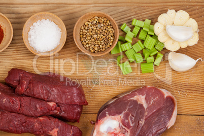 Varieties of meat with spices on wooden board