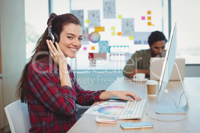 Female graphic designer working while listening music