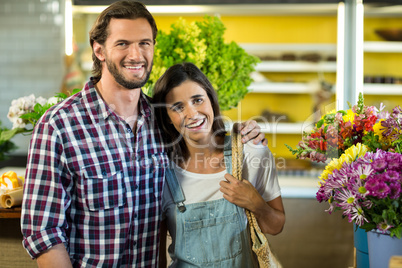 Happy couple standing in the florist shop