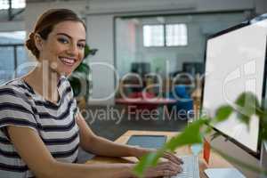 Smiling female graphic designer working on computer