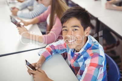 Students with digital tablet and mobile phone in classroom