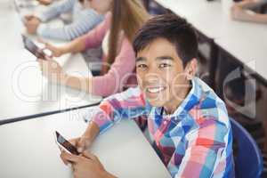 Students with digital tablet and mobile phone in classroom